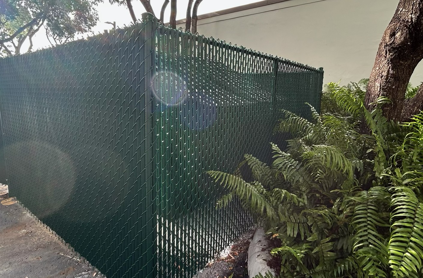 Chain link privacy fence with privacy slats for added screening around residential and commercial properties